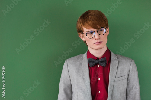 Male fashion model in eyeglasses isolated on green
