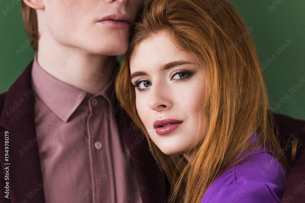 Cropped view of young male model face with girlfriend isolated on green Cropped view of young male model face with girlfriend isolated on green