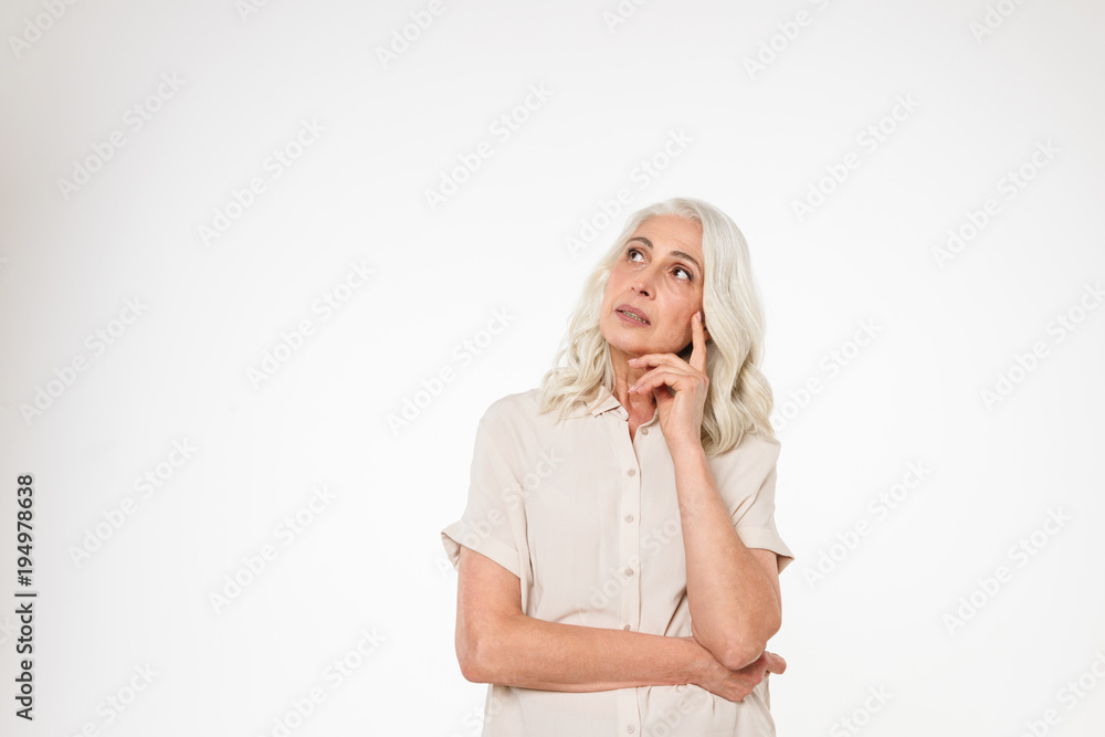 Portrait of a pensive mature woman standing with arms folded Portrait of a pensive mature woman standing with arms folded