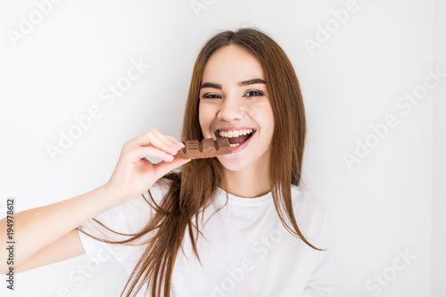 Young woman snacking on a bar of chocolate