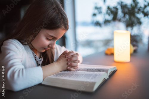 Canvas-taulu A small girl praying at home.