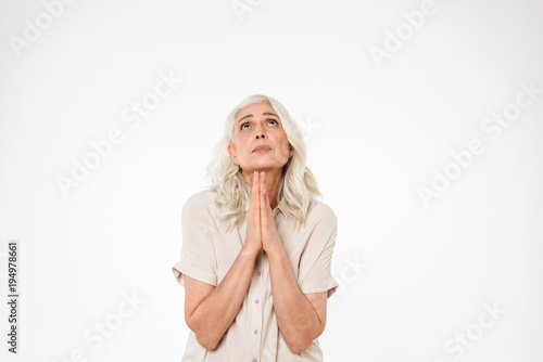 Portrait of a sad mature woman praying and looking up