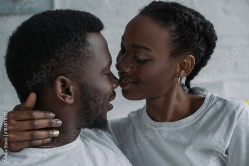 beautiful happy young african american couple able to kiss at home