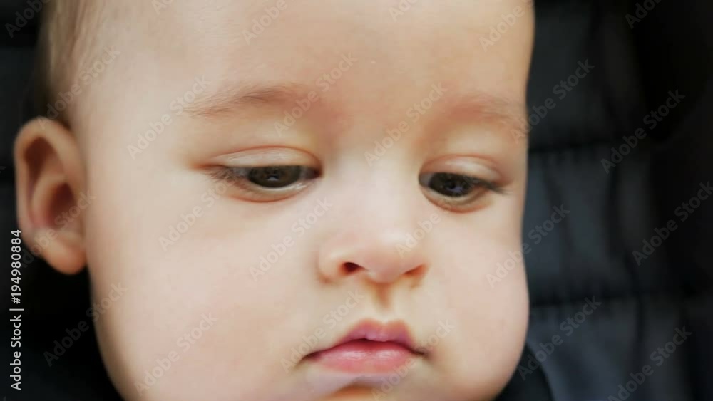 face tanned baby boy six months sitting in a stroller in the summer on vacation face tanned baby boy six months sitting in a stroller in the summer on vacation