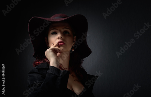 Dramatic portrait of a beautiful woman in hat .