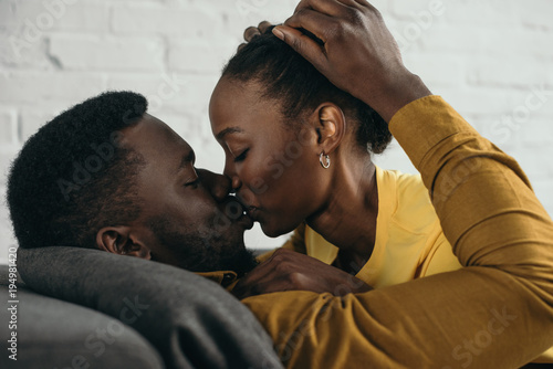 beautiful young african american couple kissing at home