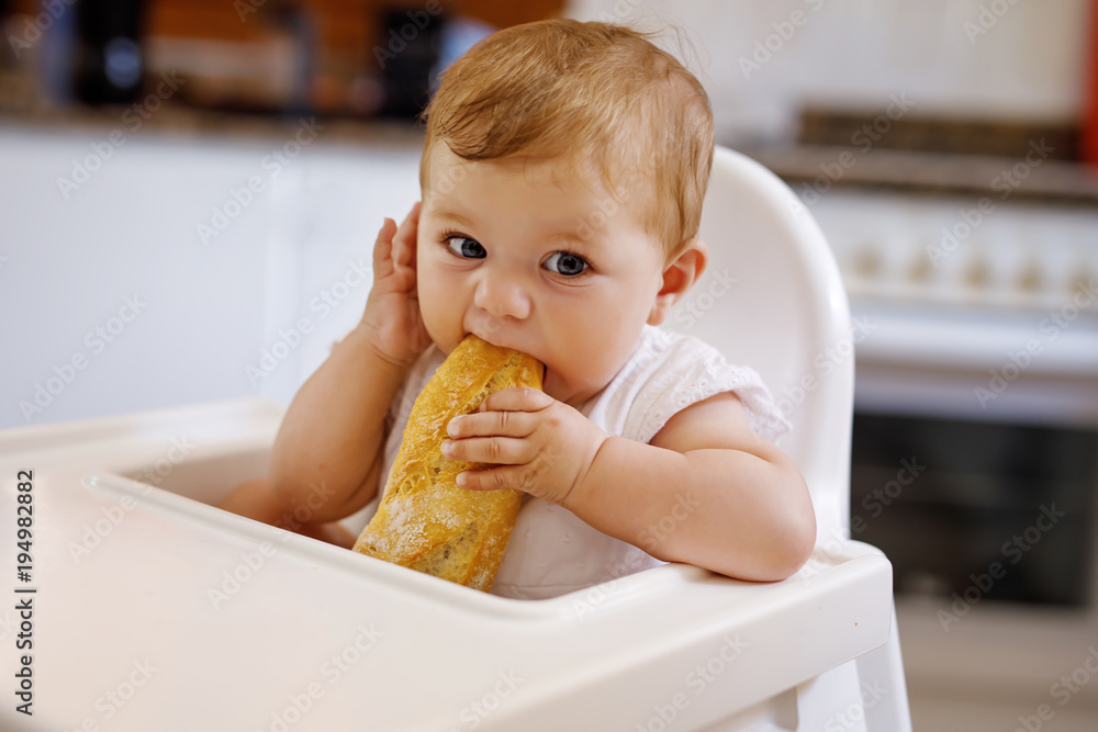 Portrait of cute little baby girl sitting in high chair and waiting for feeding Portrait of cute little baby girl sitting in high chair and waiting for feeding