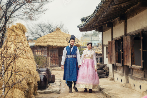 Fotografie Young Korean couple in hanbok wolking in the park