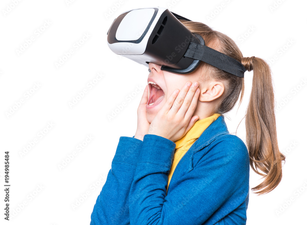 Happy little girl wearing virtual reality goggles watching movies or  playing video games. Cheerful smiling teenager looking in VR glasses. Funny  child experiencing 3D gadget technology - close up. Stock Photo