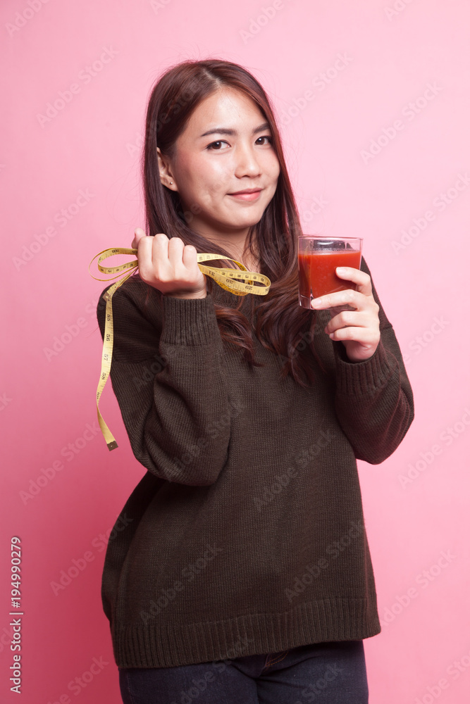 Asian woman with tomato juice and measuring tape. Asian woman with tomato juice and measuring tape.