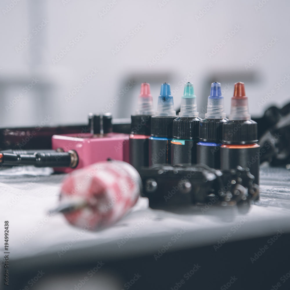 Tattoo machine and bottles with colorful ink Tattoo machine and bottles with colorful ink