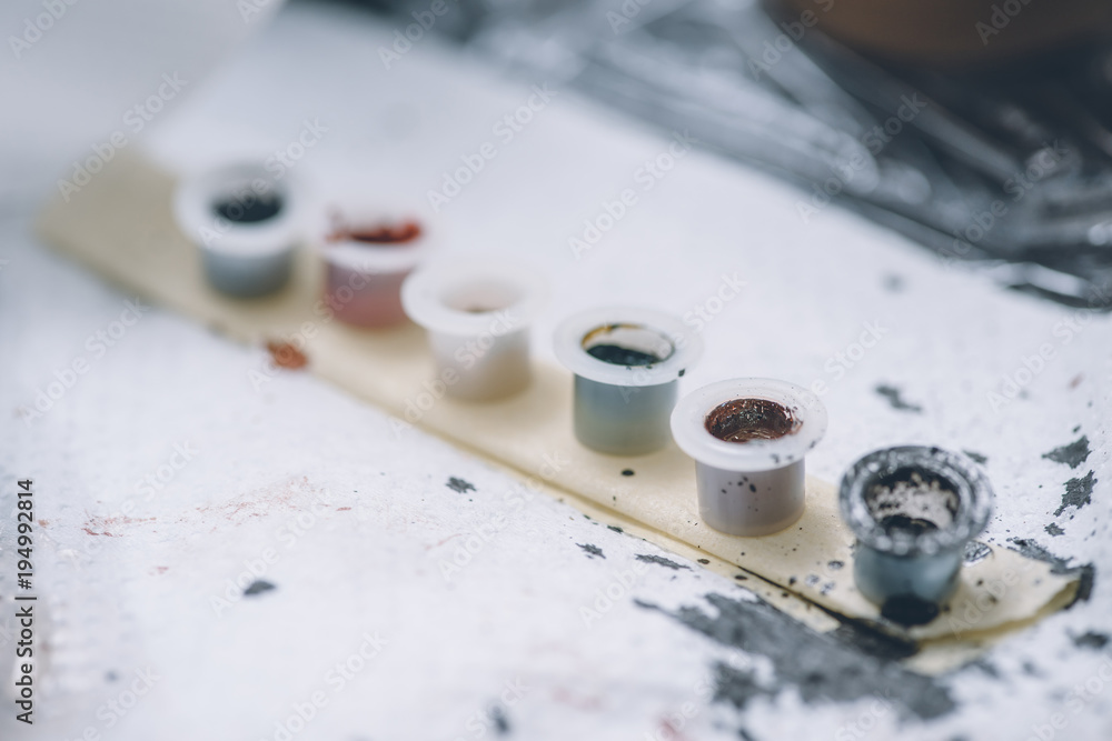 Tattoo ink cans in row on table Tattoo ink cans in row on table