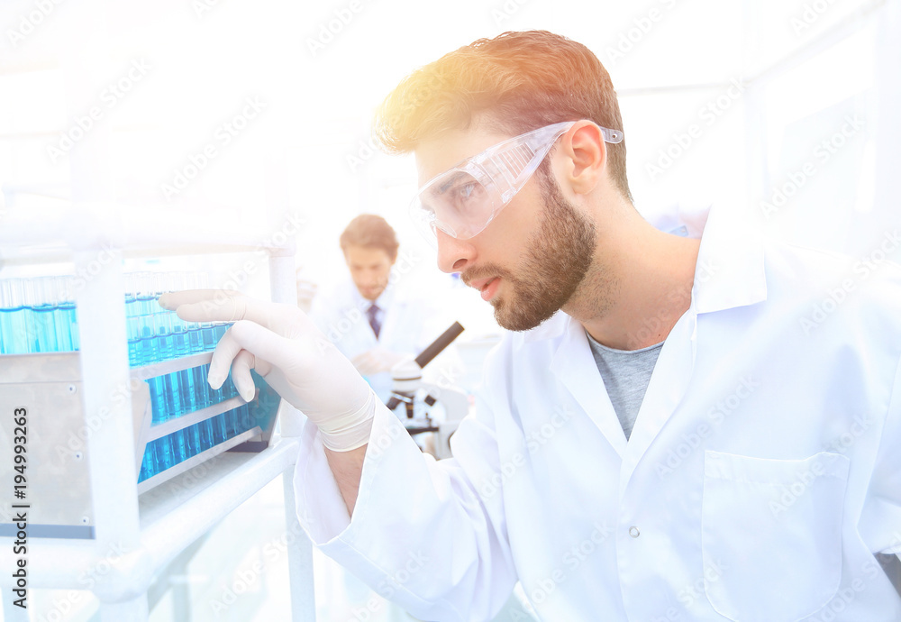 A young man doing an experiment in a chemical laboratory A young man doing an experiment in a chemical laboratory