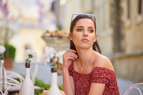 Portrait of beautiful woman sitting in outdoors cafe in Italy, drinking coffee