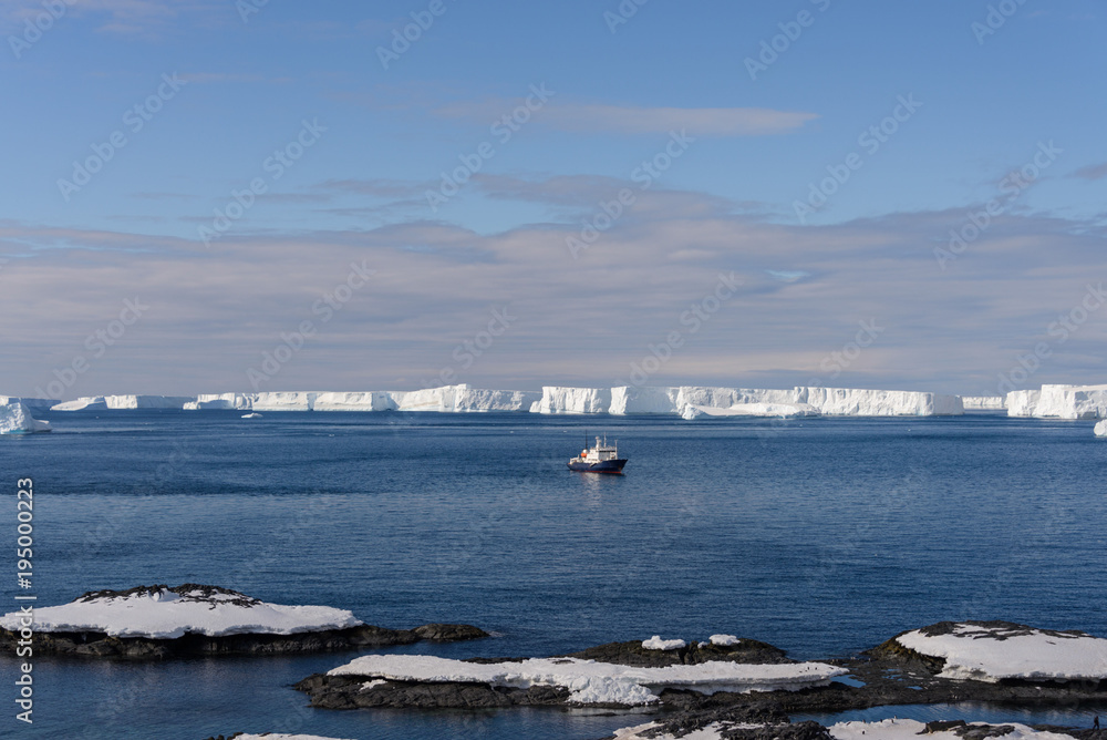 Expedition ship with iceberg aerial view
