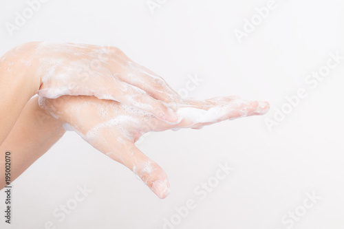 Asian woman hands are washing with soap bubbles on white background