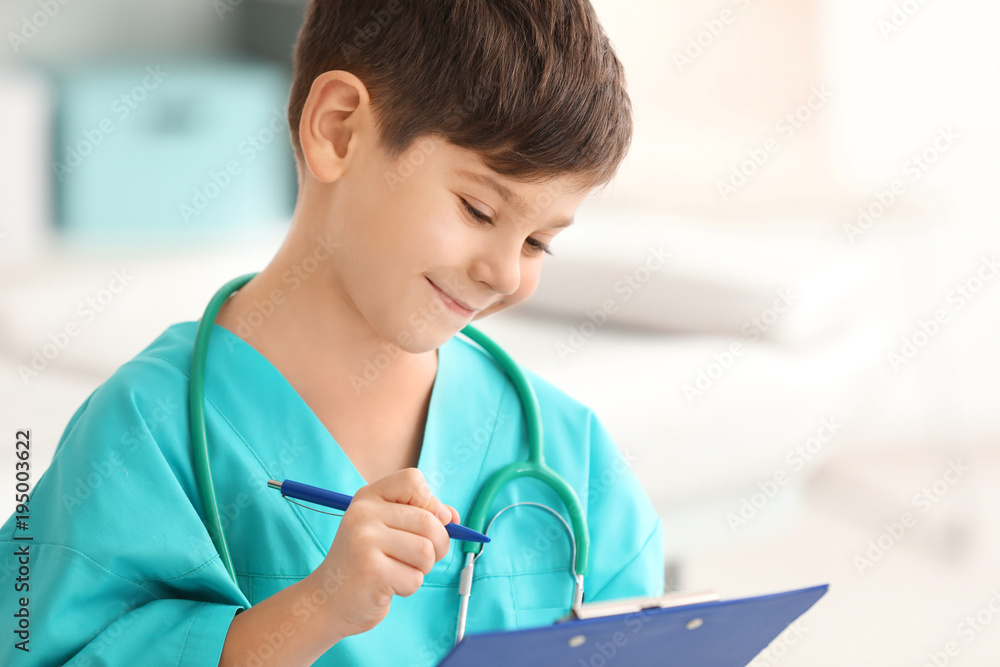 Cute little boy in doctor uniform with clipboard in hospital Cute little boy in doctor uniform with clipboard in hospital