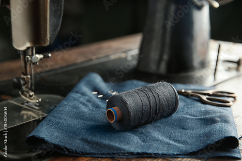 фотографія Vintage sewing machine with fabric and thread, closeup