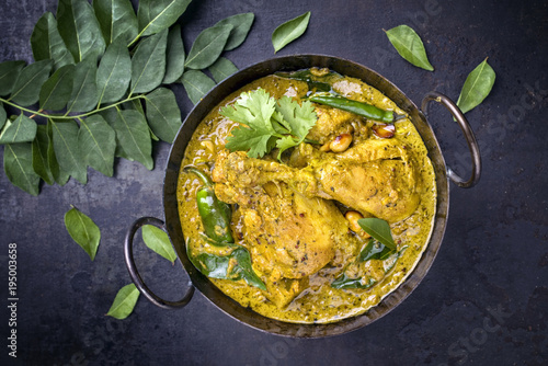 Traditional Indian curry chicken as close-up in a Korai . photo