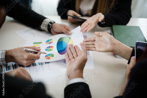 A group of business men and women are meeting together to see graphs about business marketing sales target. teamwork business meeting concept.