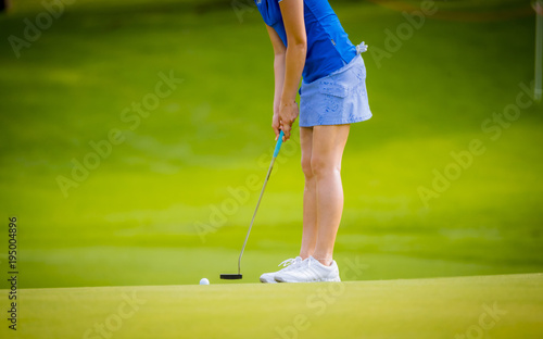 golfer pushing golf to hole on golf course 