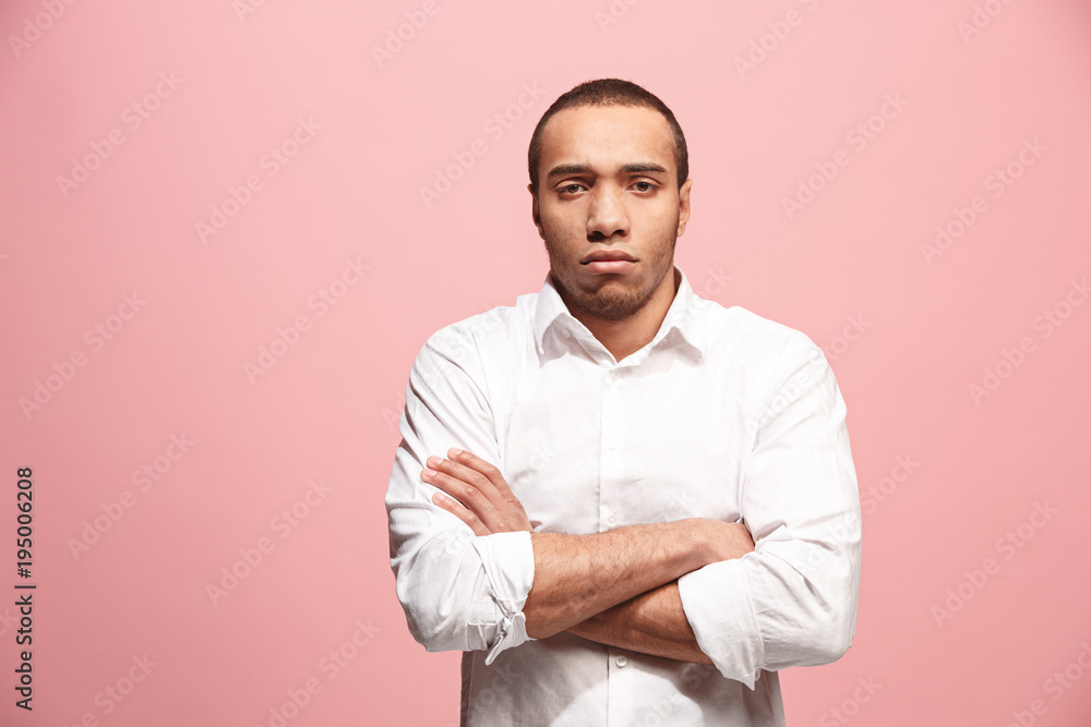 The serious businessman standing and looking at camera against pink background. The serious businessman standing and looking at camera against pink background.