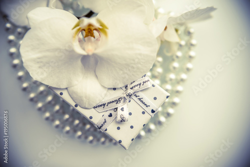 Gift box and white orchid on a white background