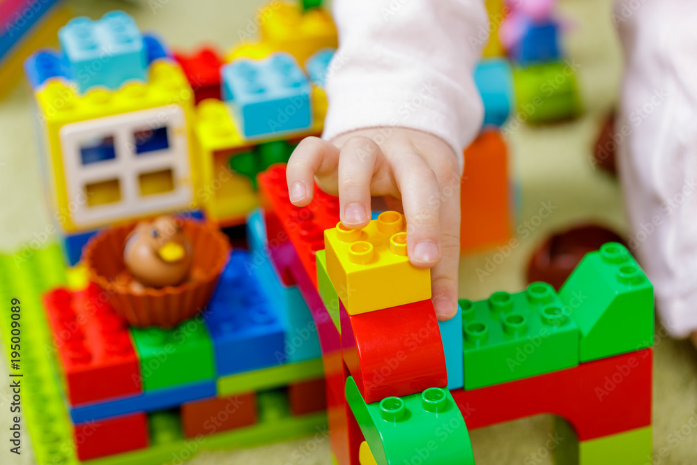 Children plastic color bricks with children hand. close up