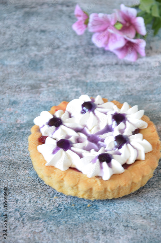 Dessert with jam and cream. Dessert with cream in a basket. Cake in lilac tones. Dessert on the background of flowers.
