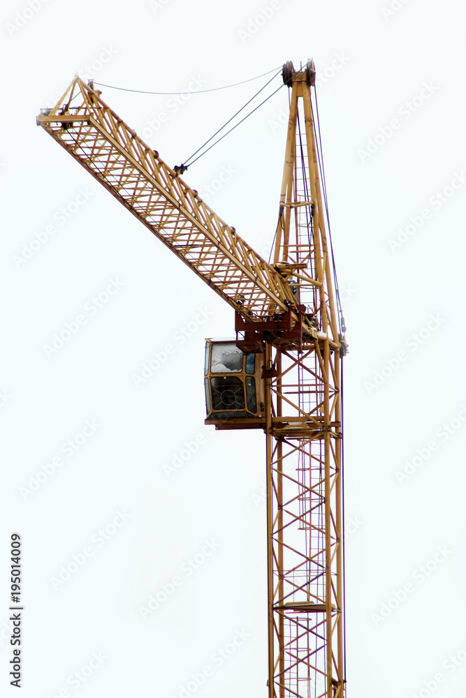 Construction crane on the construction site against the sky