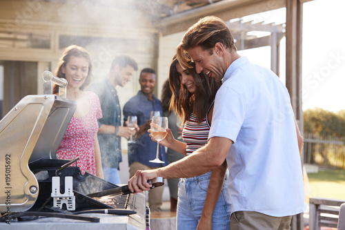 Group Of Friends Enjoying Barbecue At Home Together
