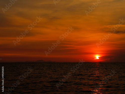 sunset last on horizontal in right frame over orange sky and ocean