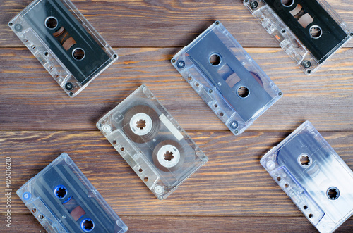 A lot of old audio cassettes. Wooden background. Space for text