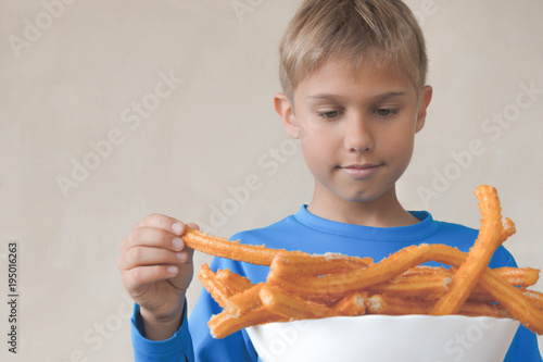 Child eating sweat Spanish dessert churros photo