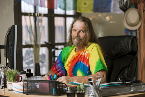 Smiling Man with Long Hair in a Colorful Office
