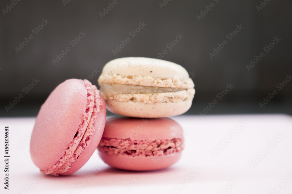 Tender pink and cream macarons on black stone background. soft focus Tender pink and cream macarons on black stone background. soft focus