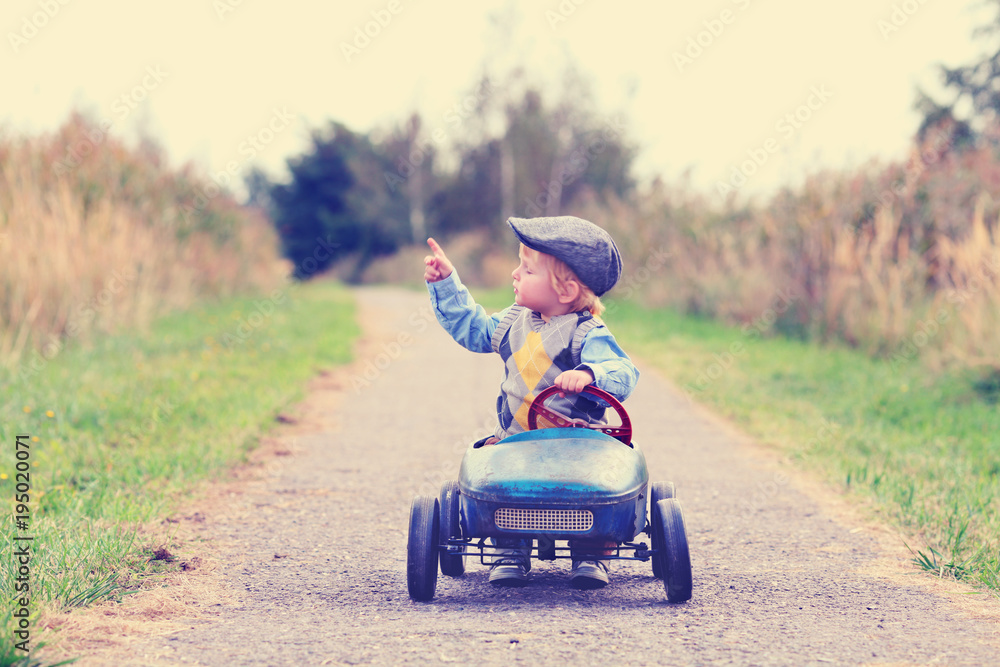 kleiner Junge im Tretauto