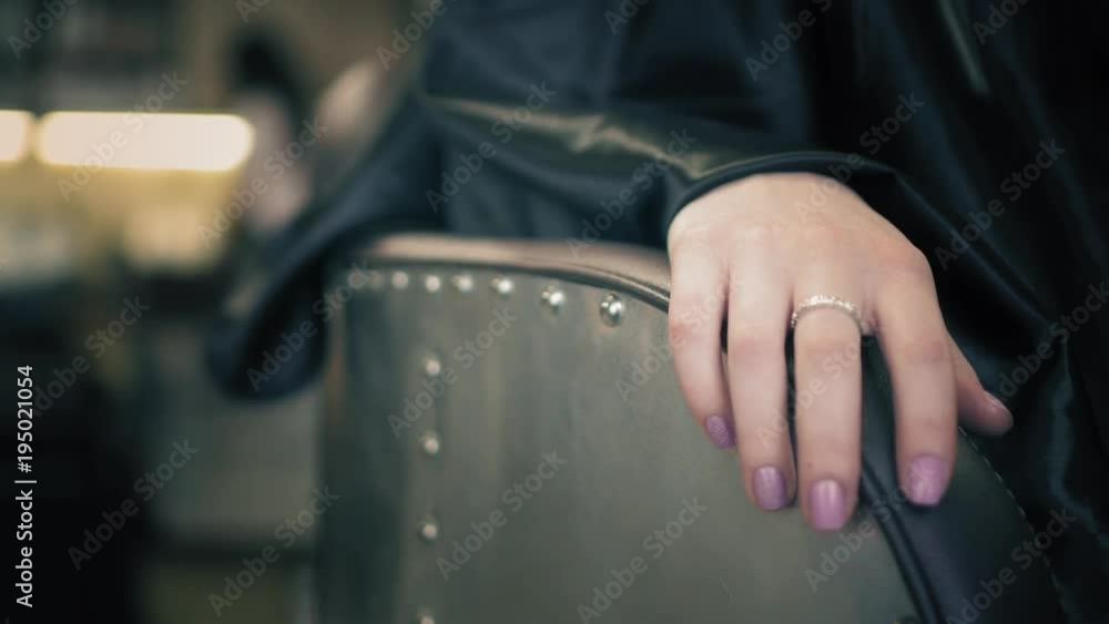 Female put a hand with beautiful ring on brown chair. Closeup view Female put a hand with beautiful ring on brown chair. Closeup view
