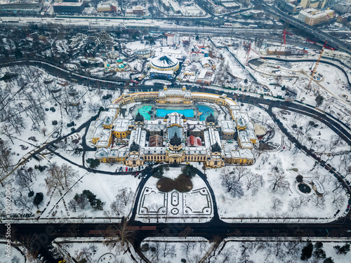 Budapest, Hungary - Aerial view of the famous Szechenyi Thermal bath from above in the snowy City Park at winter time