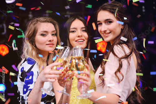 three pretty young girls with glasses of champagne