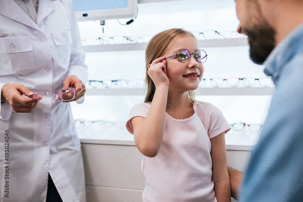 Obraz premium Dad with daughter in ophthalmology clinic