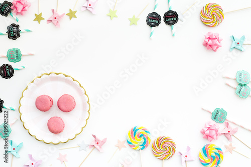 Sweets for party background. Macarons and lollipop on white top view copy space