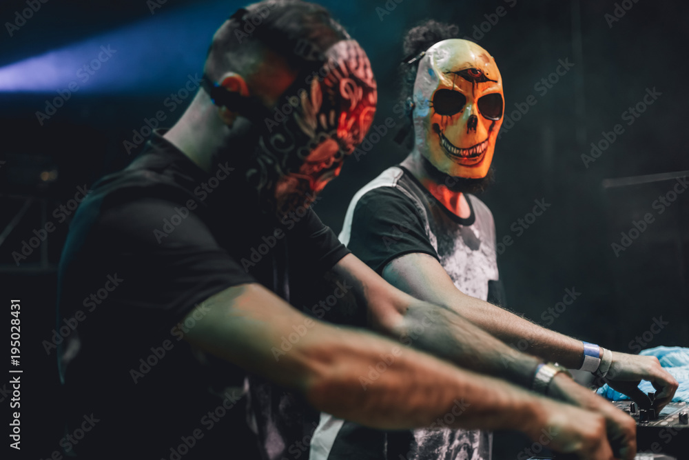 Djs with mexican masks playing mixing music at party festival. Fun, youth, entertainment and fest concept.