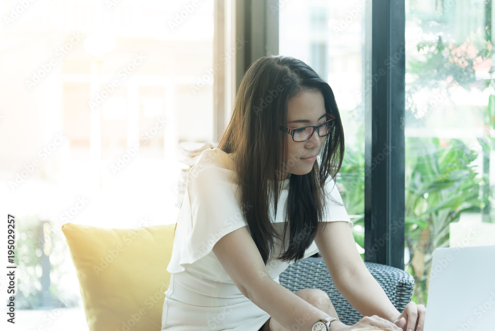 Beautiful asian attractive woman has working and typing on laptop computer for business marketing at coffee cafe in the morning with happy and relaxing time. Beautiful asian attractive woman has working and typing on laptop computer for business marketing at coffee cafe in the morning with happy and relaxing time.