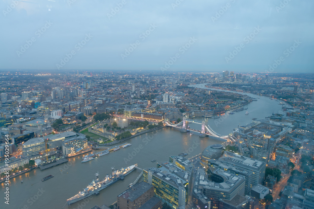LONDON - SEPTEMBER 24, 2016: Aerial view of Tower Bridge and city skyline at night. The city attracts 30 million tourists annually