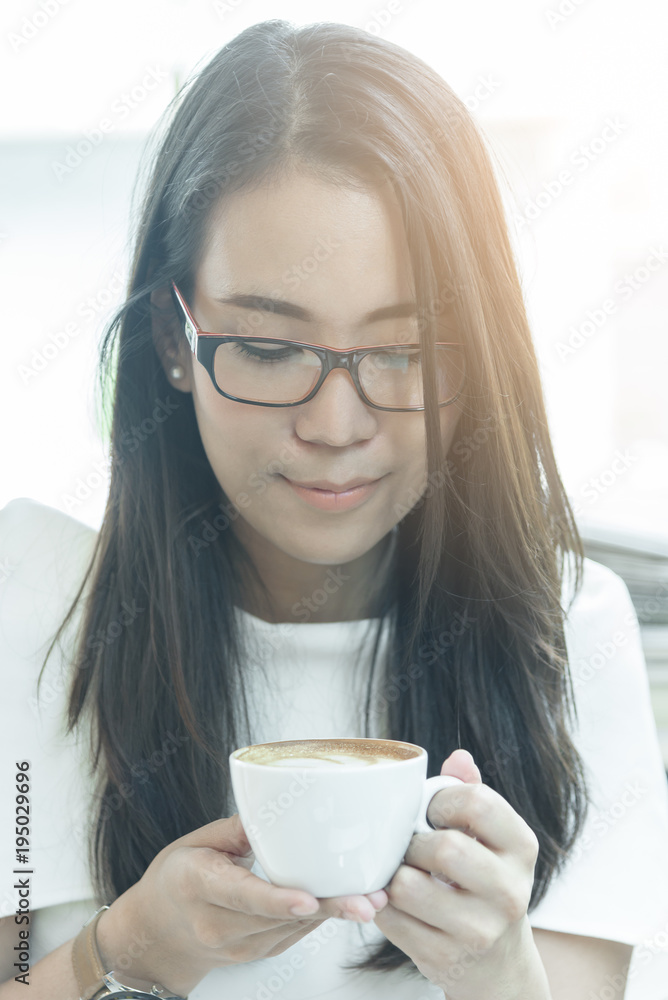 Beautiful asian attractive woman has holding and drinking a coffee at coffee cafe in the morning with happy and relaxing time. Beautiful asian attractive woman has holding and drinking a coffee at coffee cafe in the morning with happy and relaxing time.