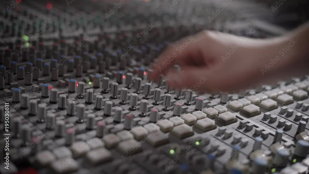 soundman is adjusting control arm on a panel of a modern multitrack recorder in an audio recording studio soundman is adjusting control arm on a panel of a modern multitrack recorder in an audio recording studio