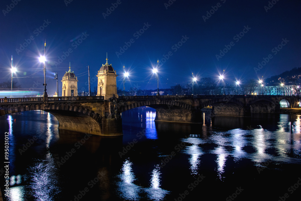 Cityscape of Prague with Charles bridge, medieval towers and colorful buildings at night, Czech Republic