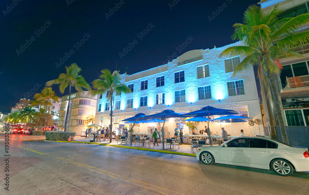 MIAMI - FEBRUARY 25, 2016: Tourists along Ocean Drive on a beautiful winter night. Miami Beach is a famous tourist attraction
