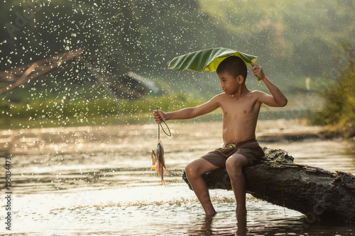 Little boy fishing in a river. photo